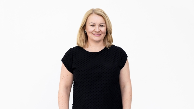 Johanna Sandberg har klätt sig på svart blus. Hon tittar leende på kamera.