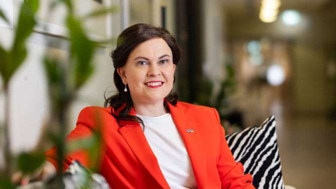 Minister Mari-Leena Talvitie tittar in i kameran och ler.