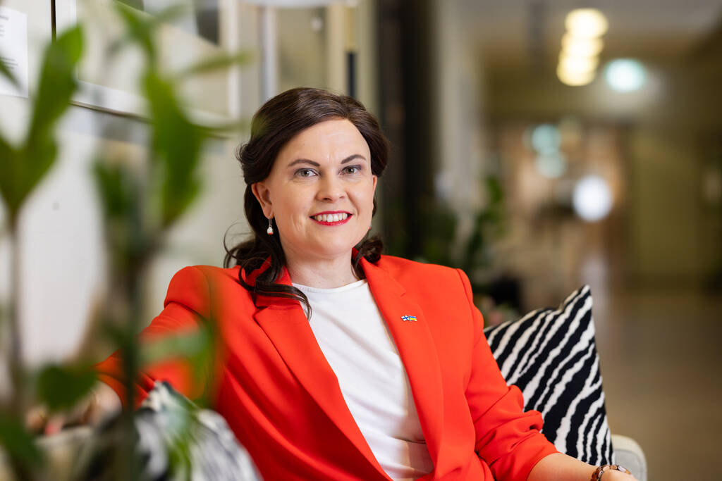 Minister Mari-Leena Talvitie tittar in i kameran och ler.